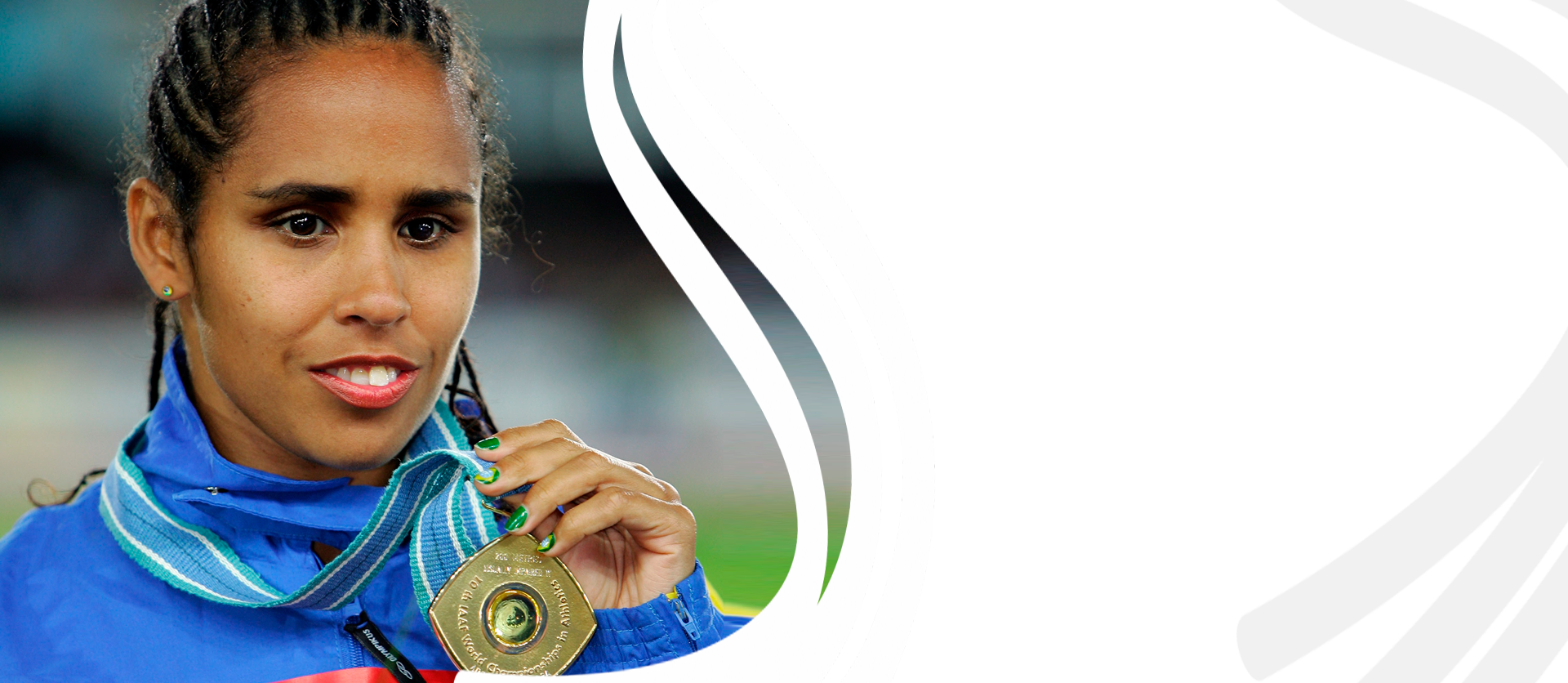 Foto de Adria Santos sorrindo com uniforme azul segurando medalha pendurada no pescoço.